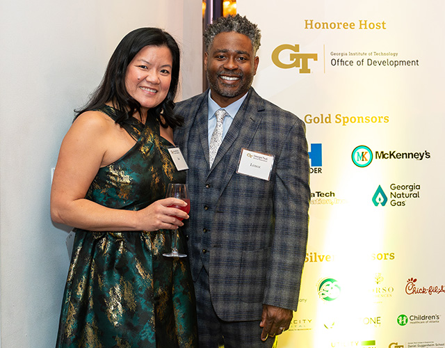 two people standing in front of  sponsors banner