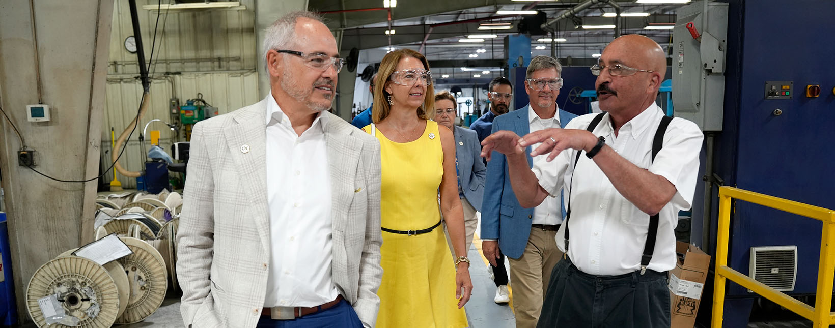 President Cabrera and a few other GT representatives speaking to someone on a factory floor
