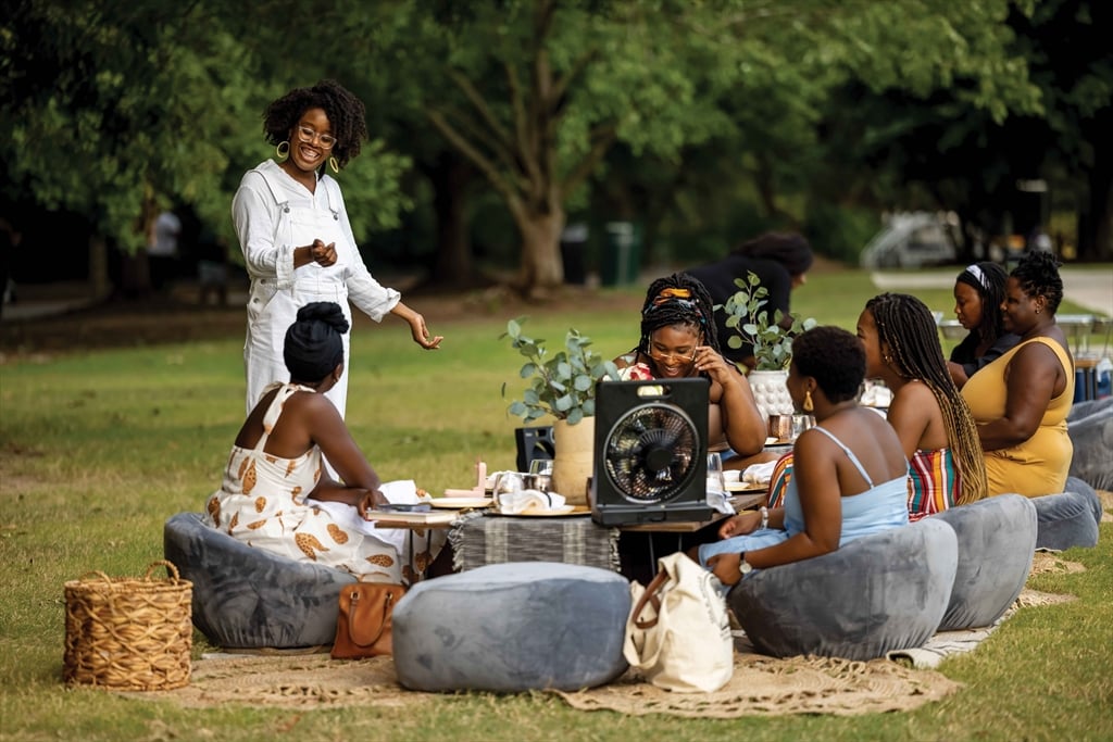 Katie Mitchell and her friends talking in a park.