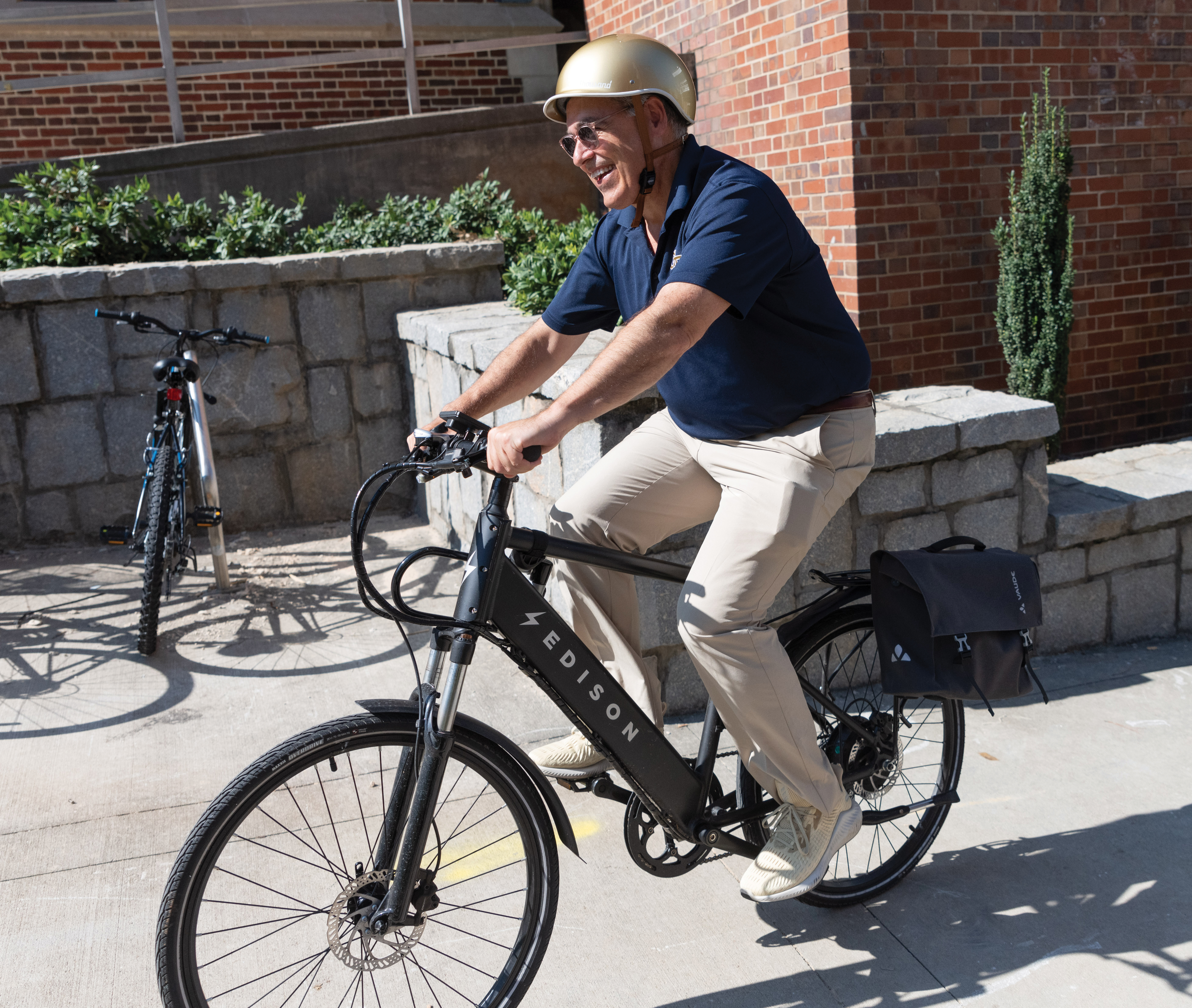 Angel Cabrera riding an e-bike wearing a gold helmet.