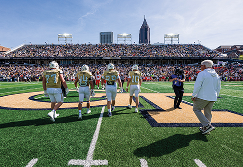 Keylan Rutledge (#77), Kyle Efford (#44), Jordan van den Berg (#99), and Haynes King (#10) walk out for the coin toss against Syracuse.