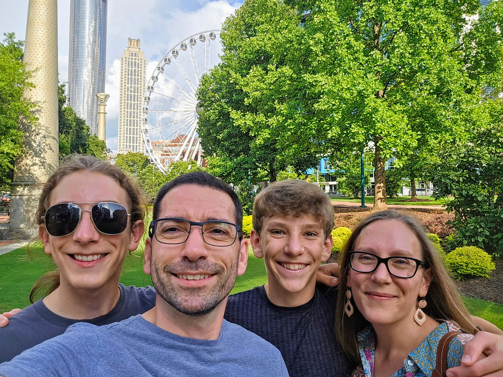 Photo of four people in a family smiling at the camera. 