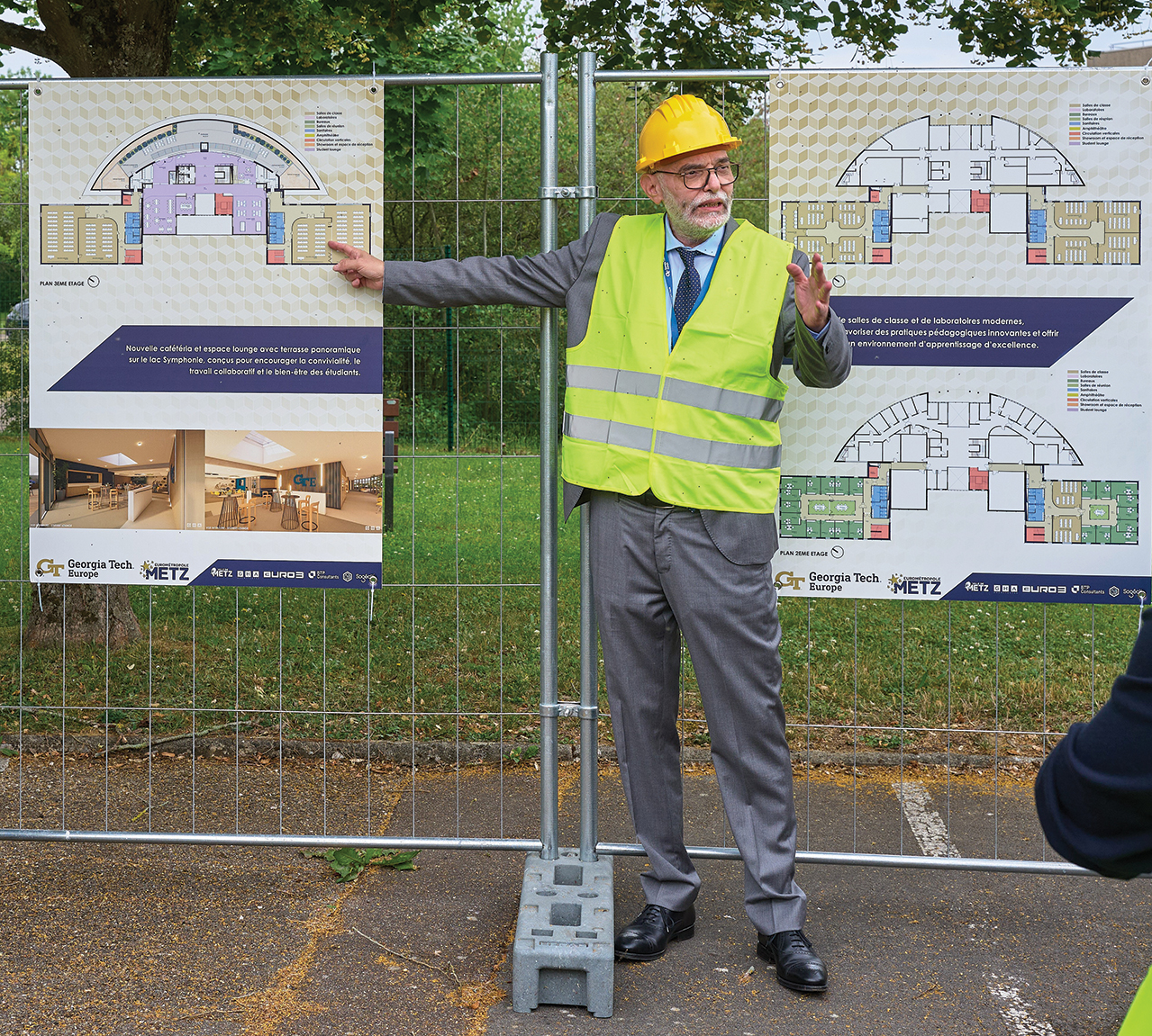 GTE President standing in front of a fence that shows plans for the GTE expansion. 