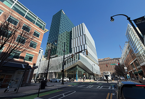 Interior of a building with multiple couches, seating areas, and a coffee shop in the background. 