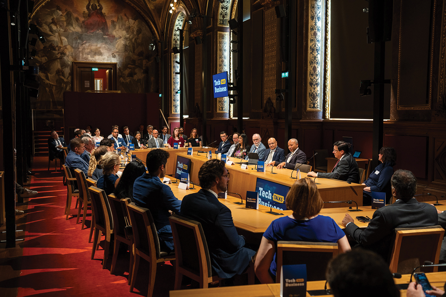 People sitting around a conference table inside Luxembourg Palace.