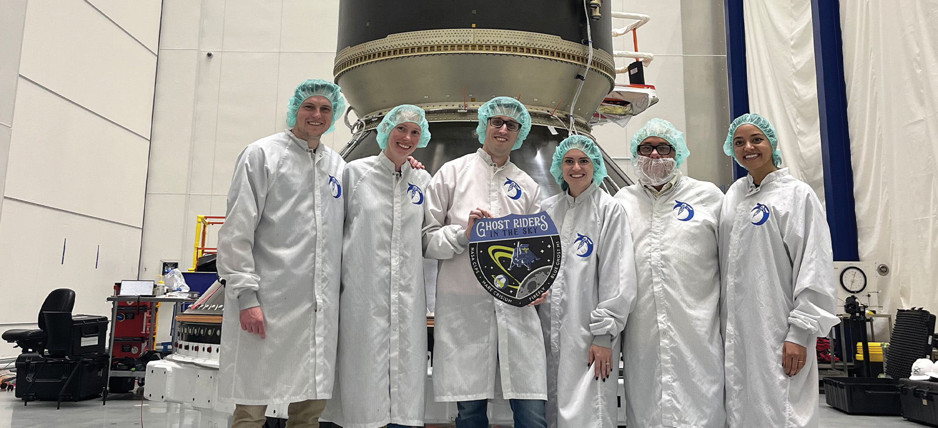 group of scientists in front of a space craft