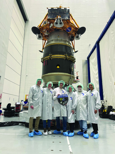 group of scientists in fron of the space rocket