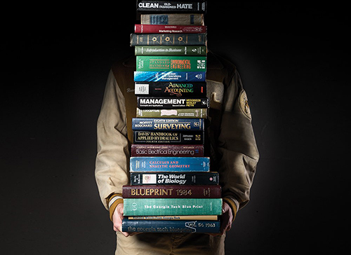 George P. Burdell holding books, face obscured