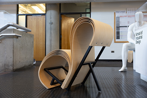 A bent wood chair in the shape of a S.
