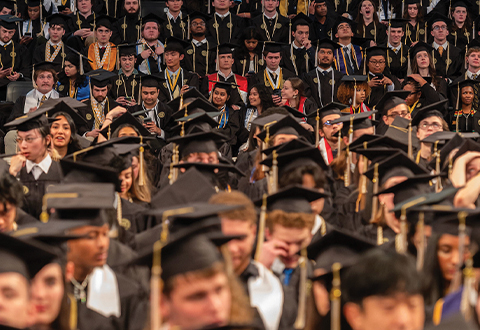 A crowd of new Georgia Tech graduates at commencement wearing their graduation caps.
