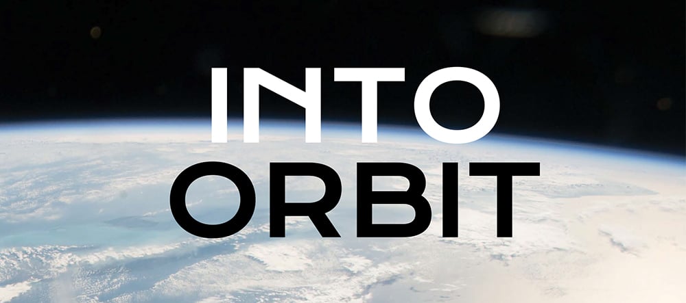 A photo from space showing a wide view of the curved Earth and the blackness of space above it. The title "INTO ORBIT" is written in large white letters in the center of the image.