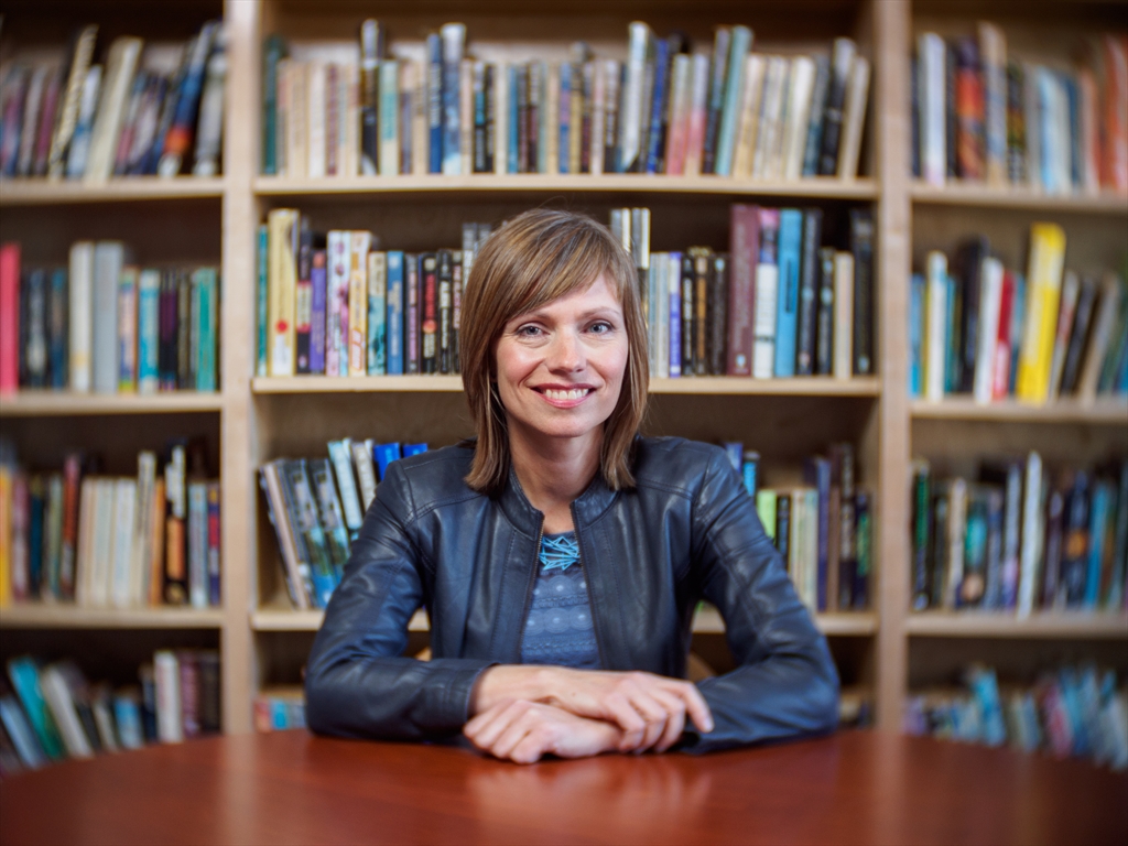 Lisa Yaszek poses in front of a bookshelf