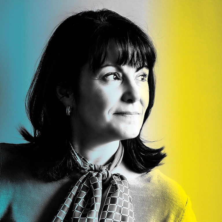 A portrait of a dark-haired woman looking to the side, with a yellow filter on the right and a blue filter on the left.